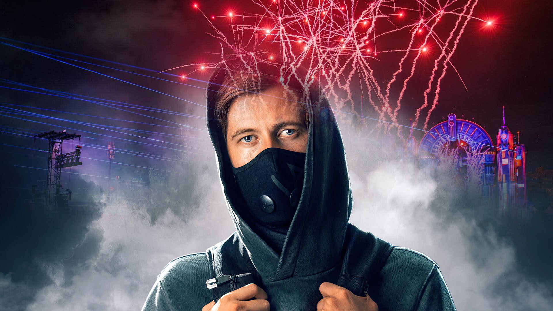 Alan Walker in black hoodie and mask with glowing festival stage behind him at night.