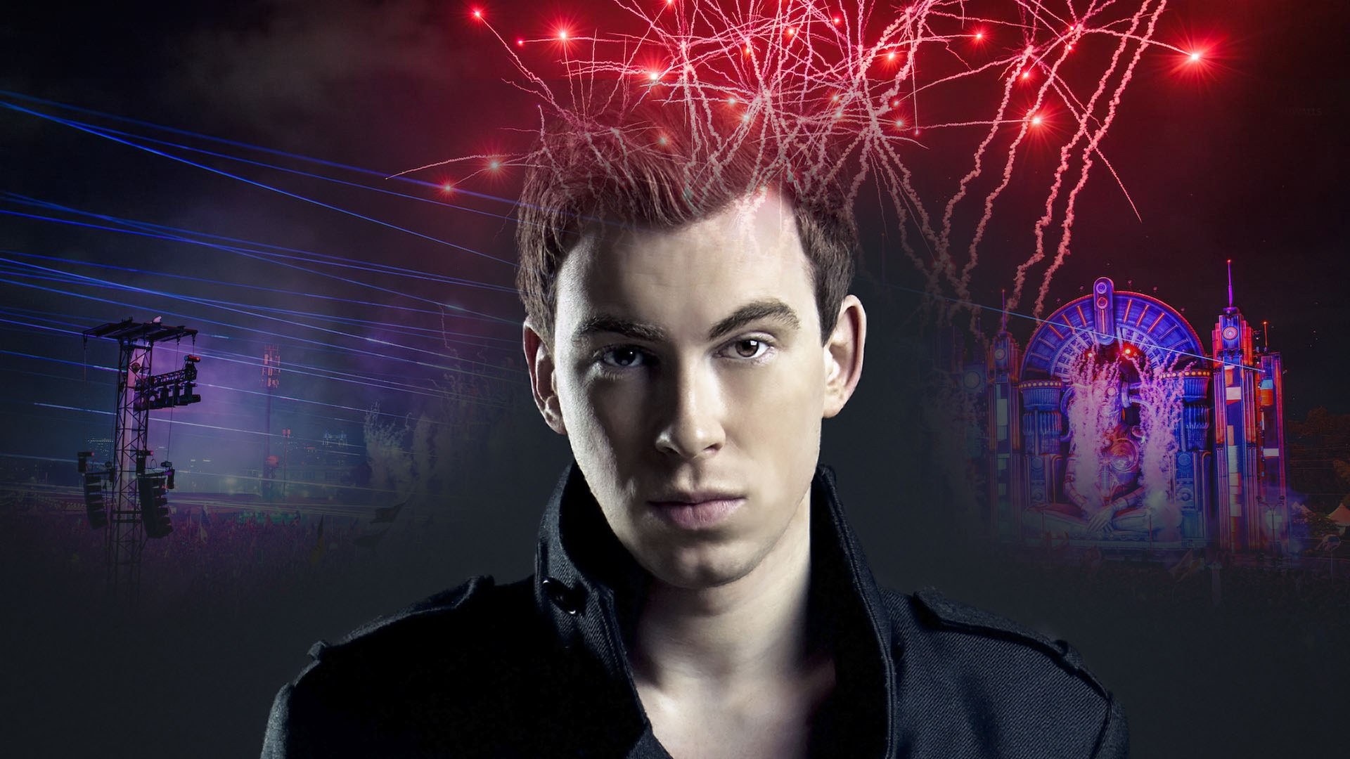Man in a black high-collared jacket under red sparks, with blue laser beams and a neon festival stage behind him.