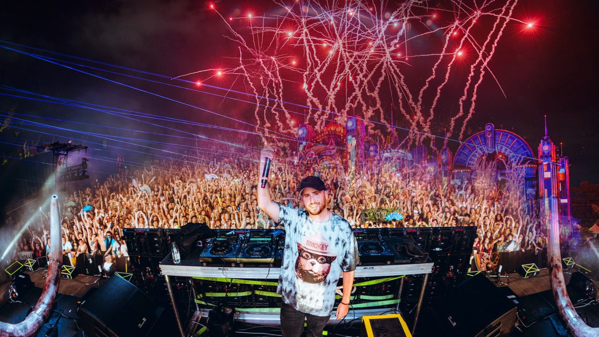 DJ выступает на EDC Orlando перед огромной толпой — над сценой неоновые молнии.