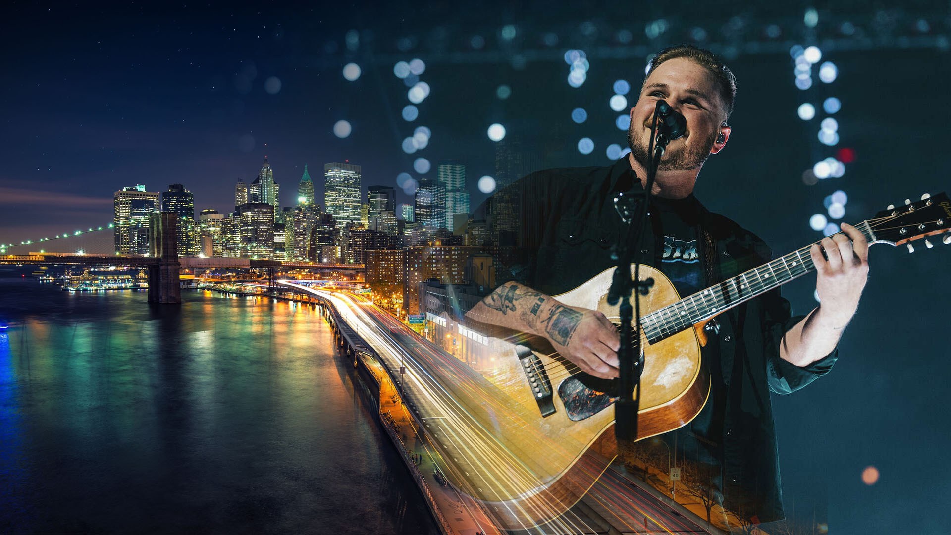 Bearded man singing into a mic while playing acoustic guitar, overlaid on a glowing night city skyline with a bridge.